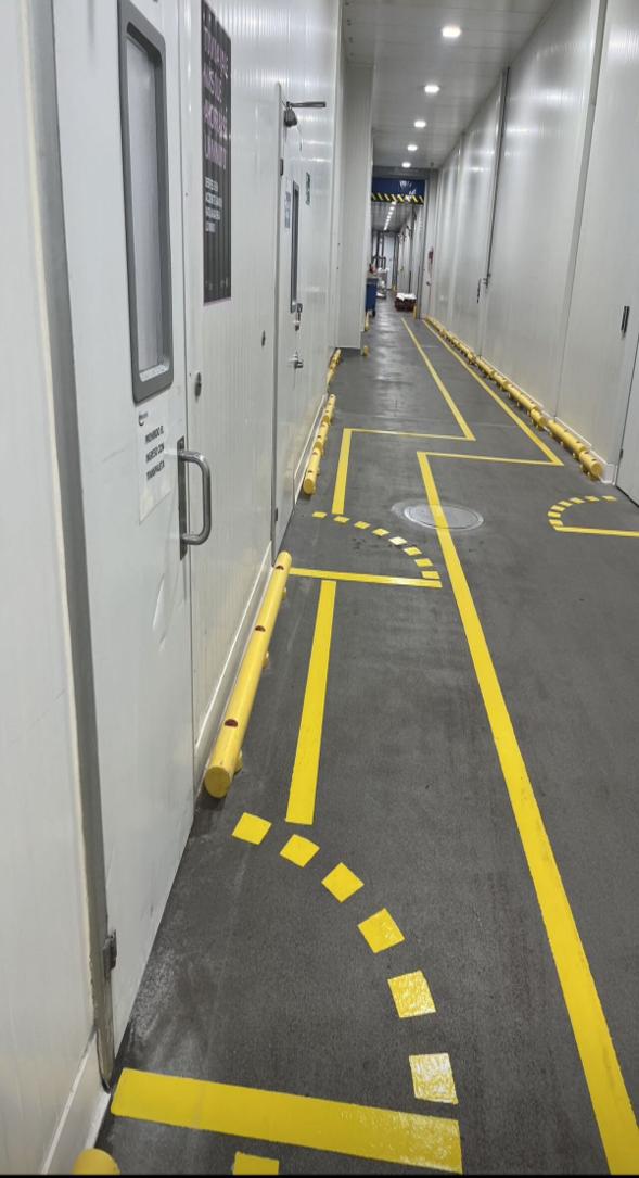 Pasillo con señalización de tránsito peatonal y vehicular en amarillo